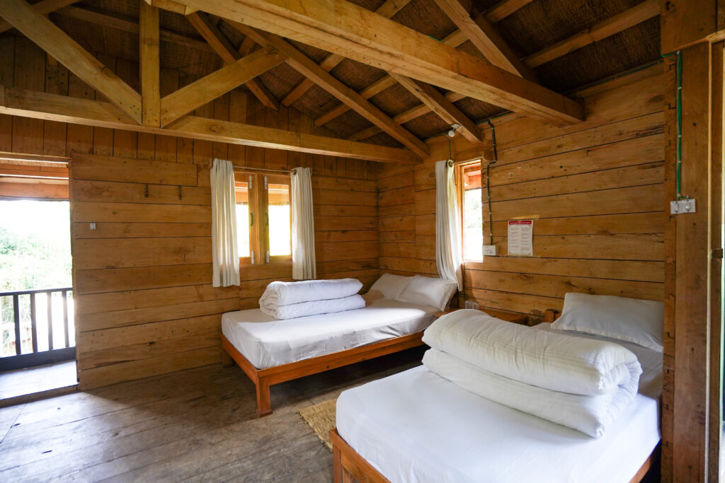 Eco‑friendly lodge room with rustic wooden decor and Himalayan mountain views at Kalsee Eco Lodge.